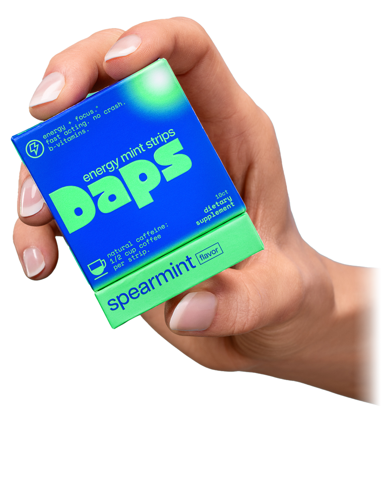 Hand holding a box of Daps energy mint strips with spearmint flavor on a white background